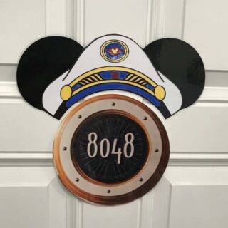 Mickey Mouse ears with a captain's hat sitting on top of the stateroom number sign