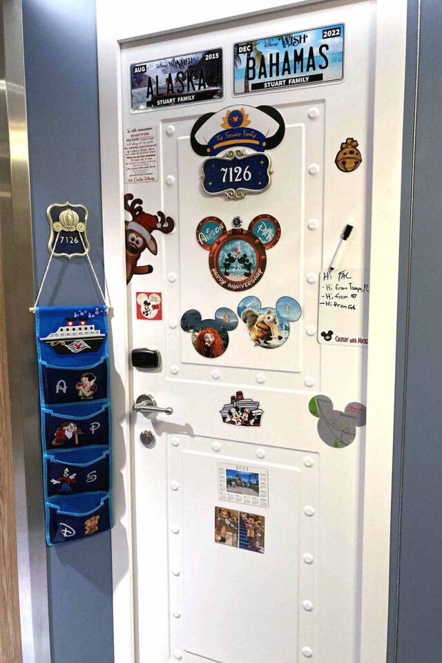 Stateroom door with Mickey Mouse ears over the stateroom number and several other decorative magnets