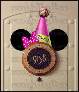 Minnie Mouse ears with a pink birthday hat and bow sitting on top of the stateroom number sign