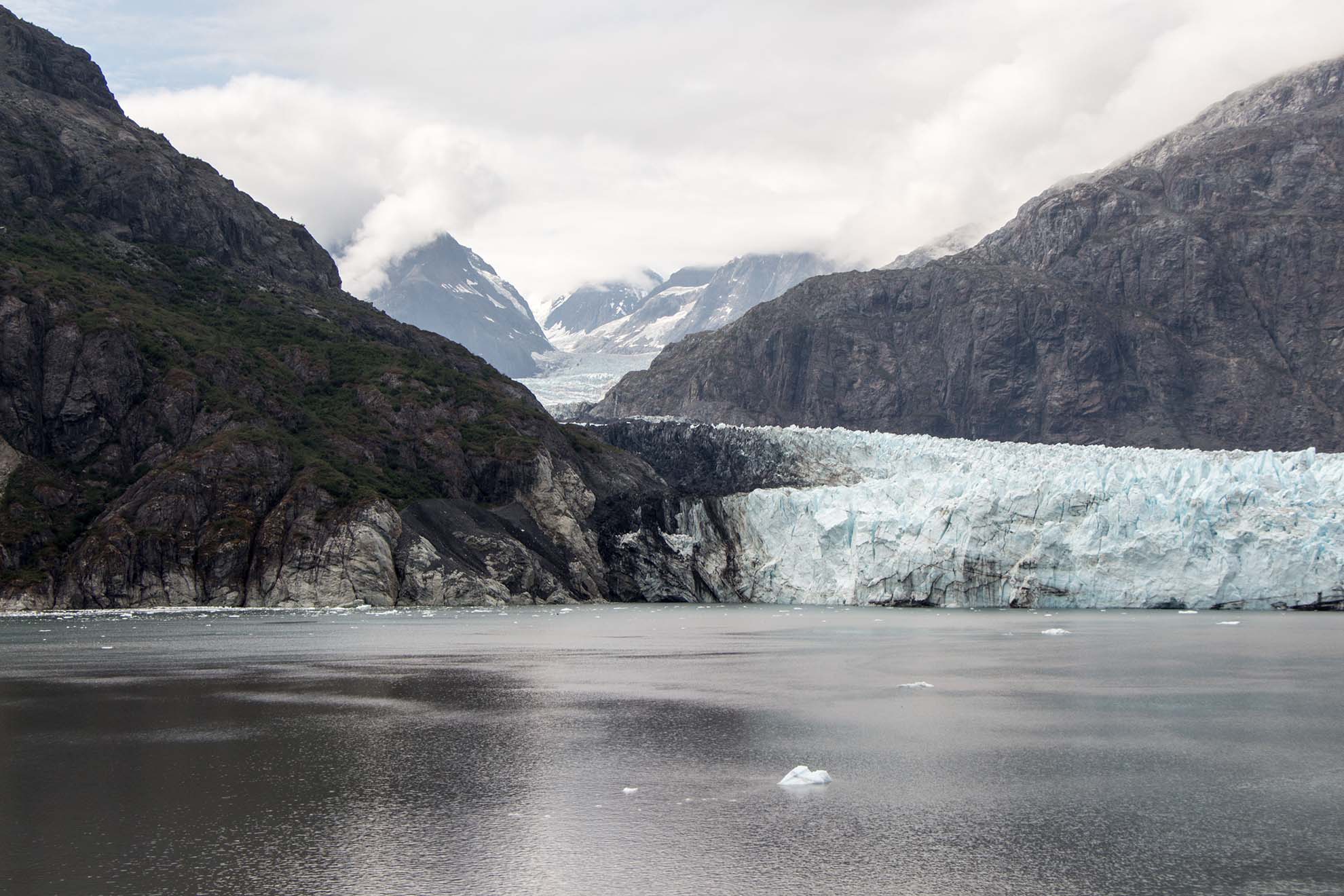 Glacier and mountains with water in the foreground.