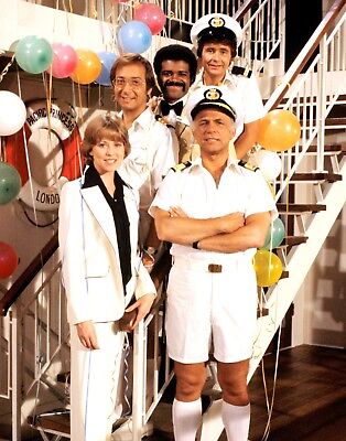 The main crew from the TV show "Love Boat" standing on a stairway on their cruise ship.